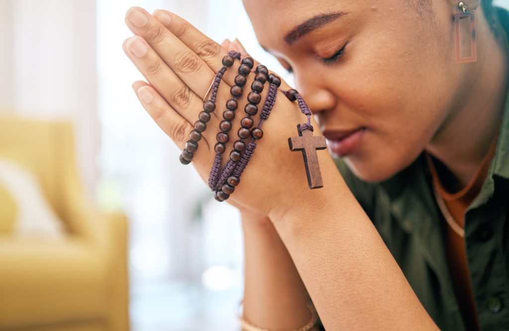 jeune femme priere et chapelet a la maison