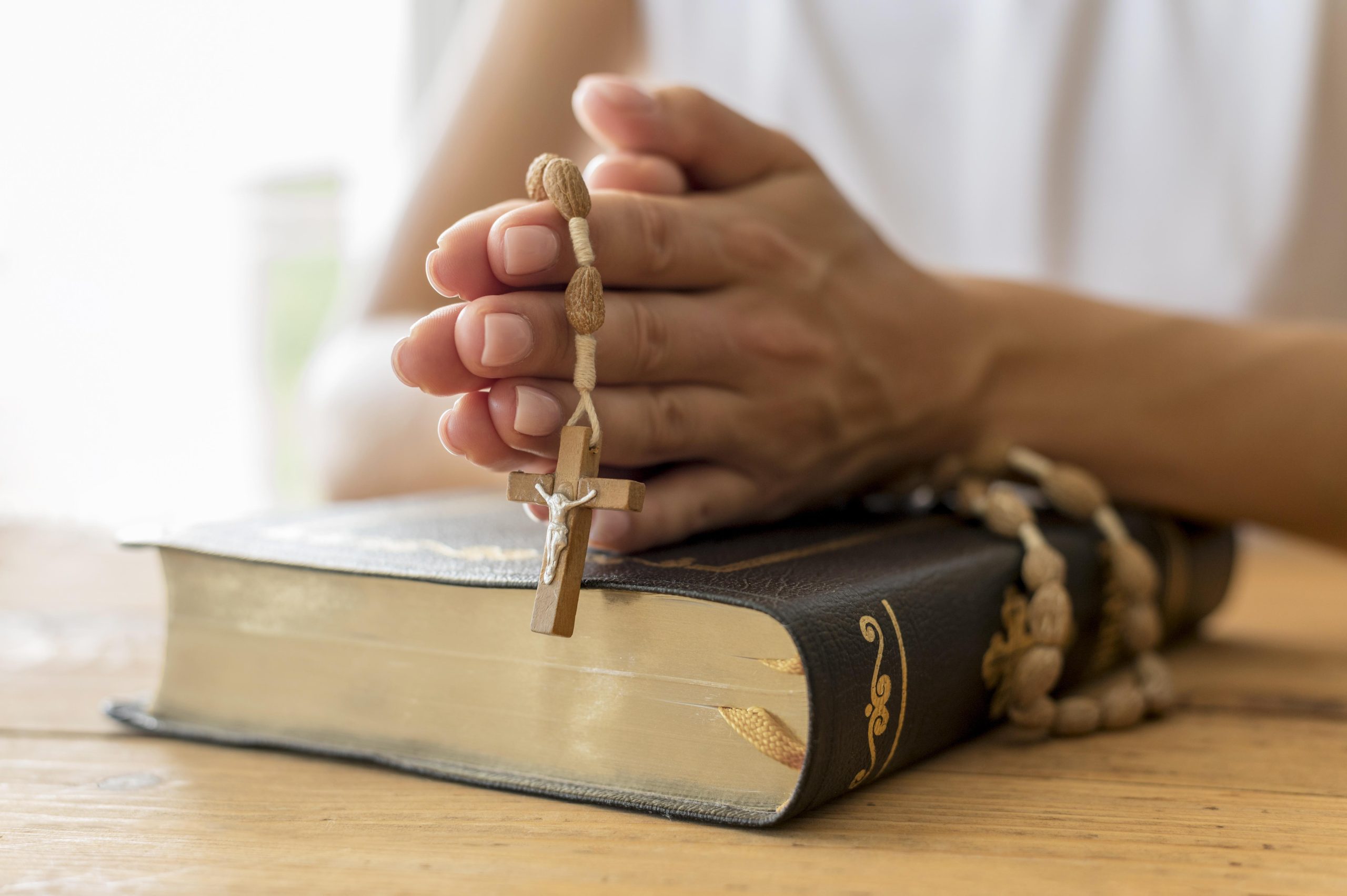 personne priant avec chapelet et livre sacre
